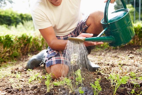 A gardener pruning plants in an urban Bethnal Green garden.